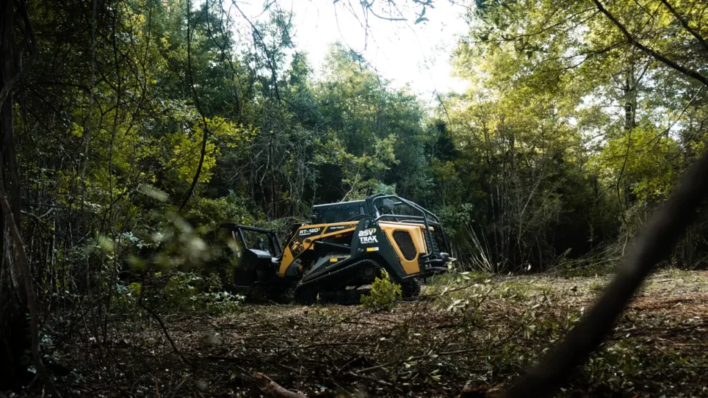 Forestry mulcher opening up a wooded lot, cleared ground in front